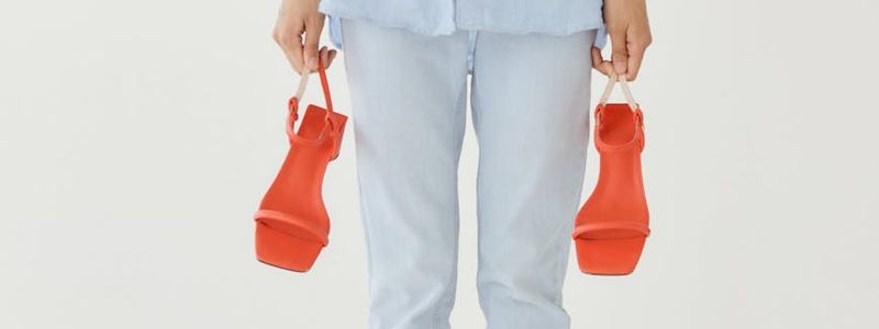 A person holding a challenging balance pose against a minimalist background.