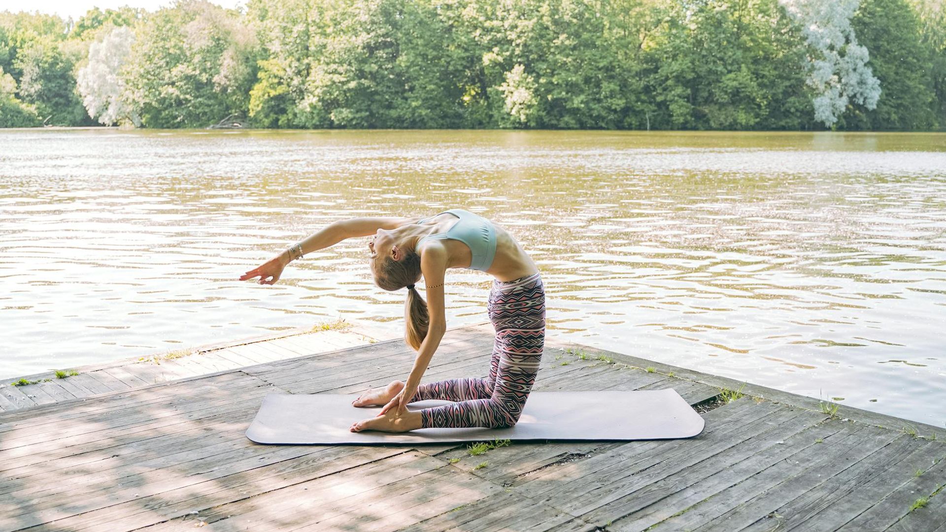 A serene person performing a stretching exercise in a calm, dark environment.