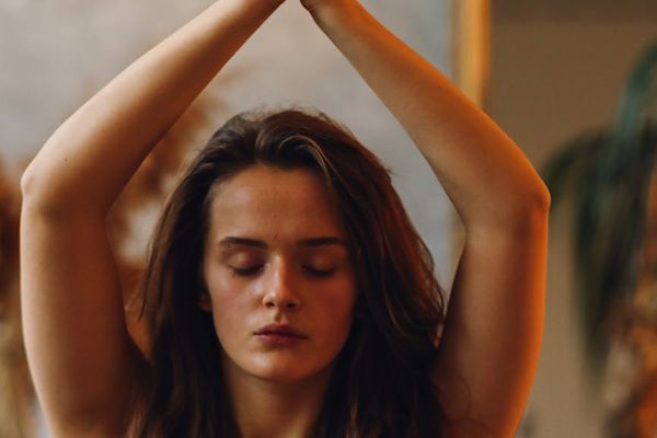 Person in mid-flow of a yoga sequence, showing concentration and balance.